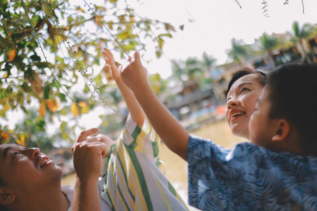 Two children reaching up towards tree branches