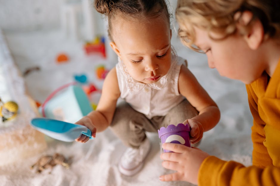 Two children playing with toys in a sandbox, enjoying a fun and creative moment.